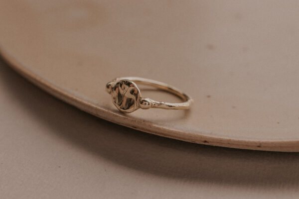 Signet style ring with two gold dots on either side