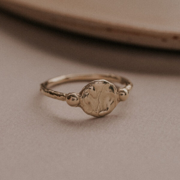 Signet style ring with two gold dots on either side