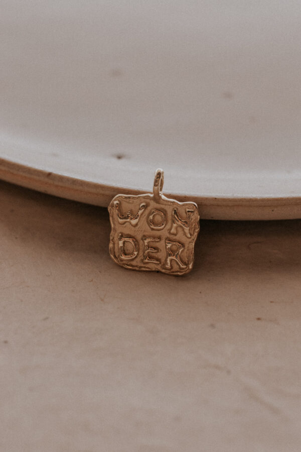 Gouden of zilveren amulet hanger met tekst gemaakt door bobini roots
