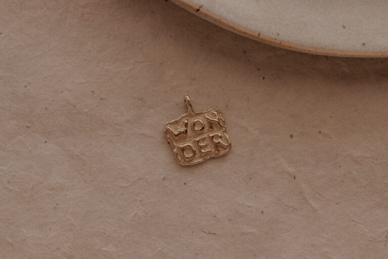 Gouden of zilveren amulet hanger met tekst gemaakt door bobini roots