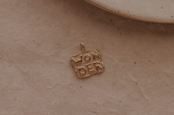 Gouden of zilveren amulet hanger met tekst gemaakt door bobini roots
