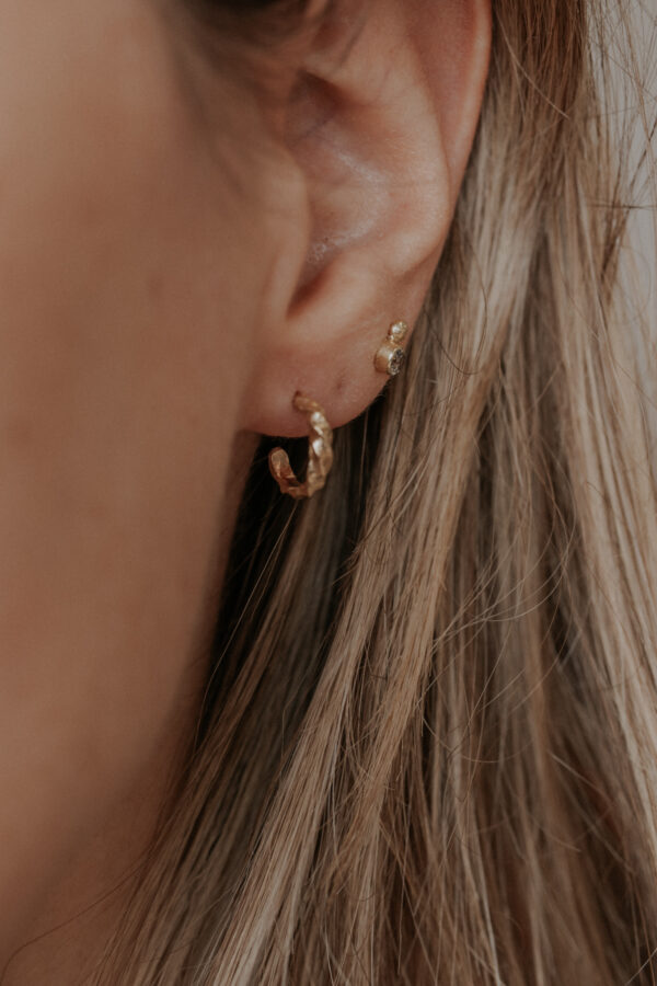 Girl wearing tiny vines hoop earrings